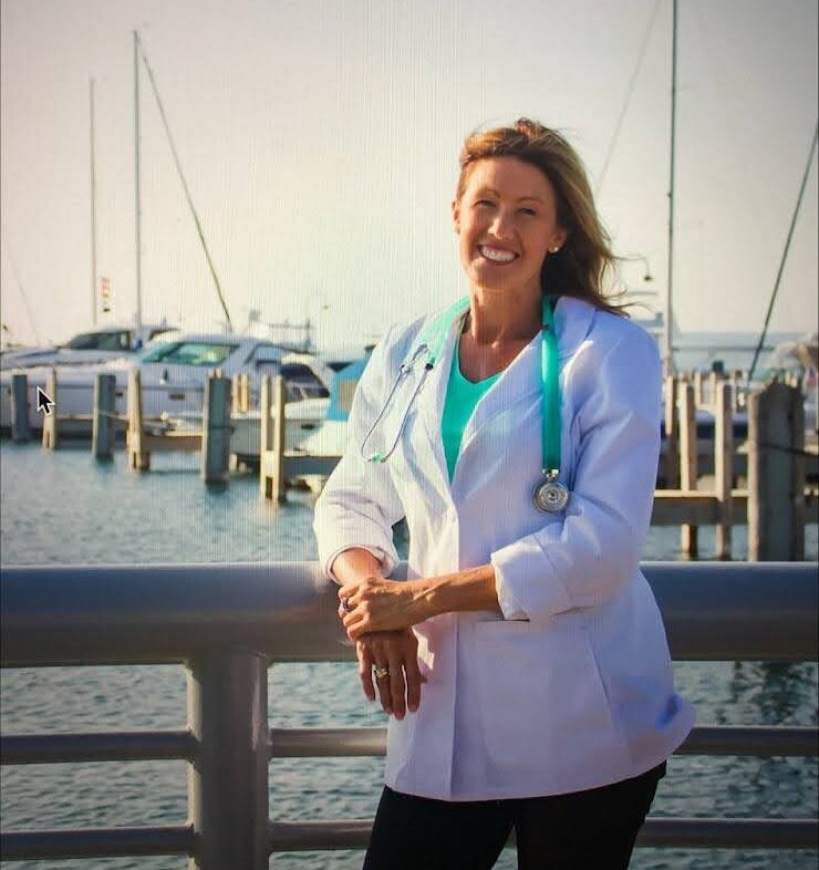 a woman standing in front of a body of water